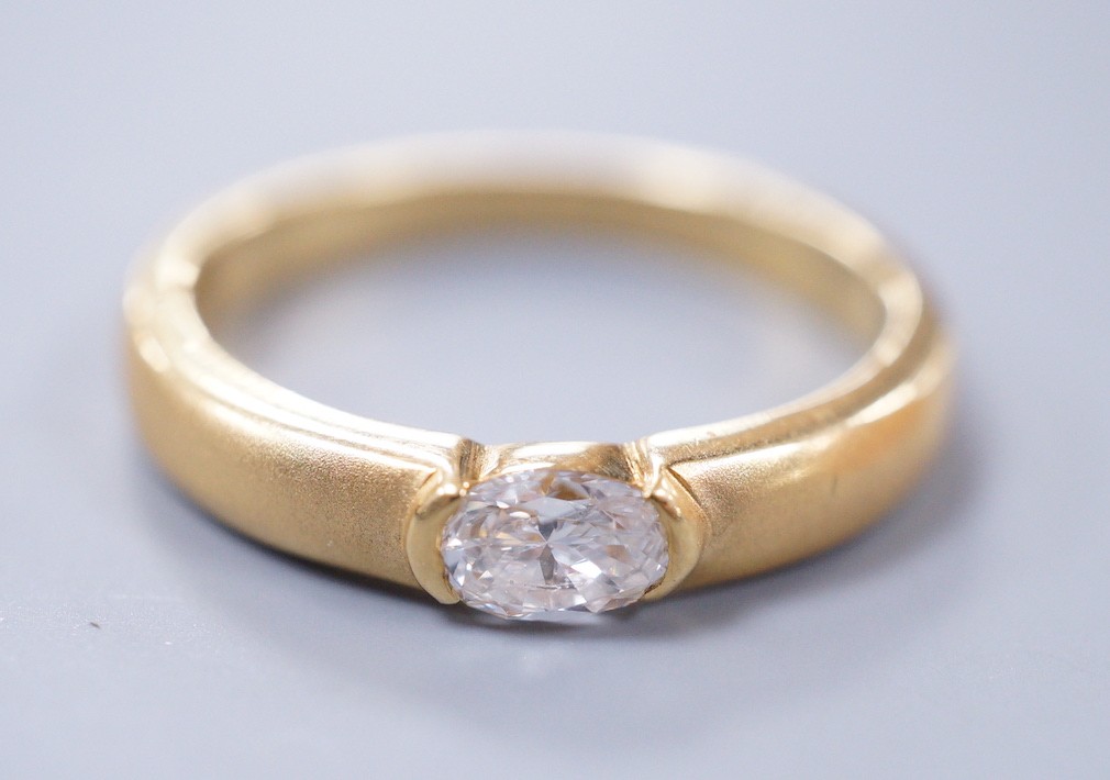 A modern 18ct gold and oval cut solitaire diamond set ring, with sandblasted shank, size K, gross weight 4 grams